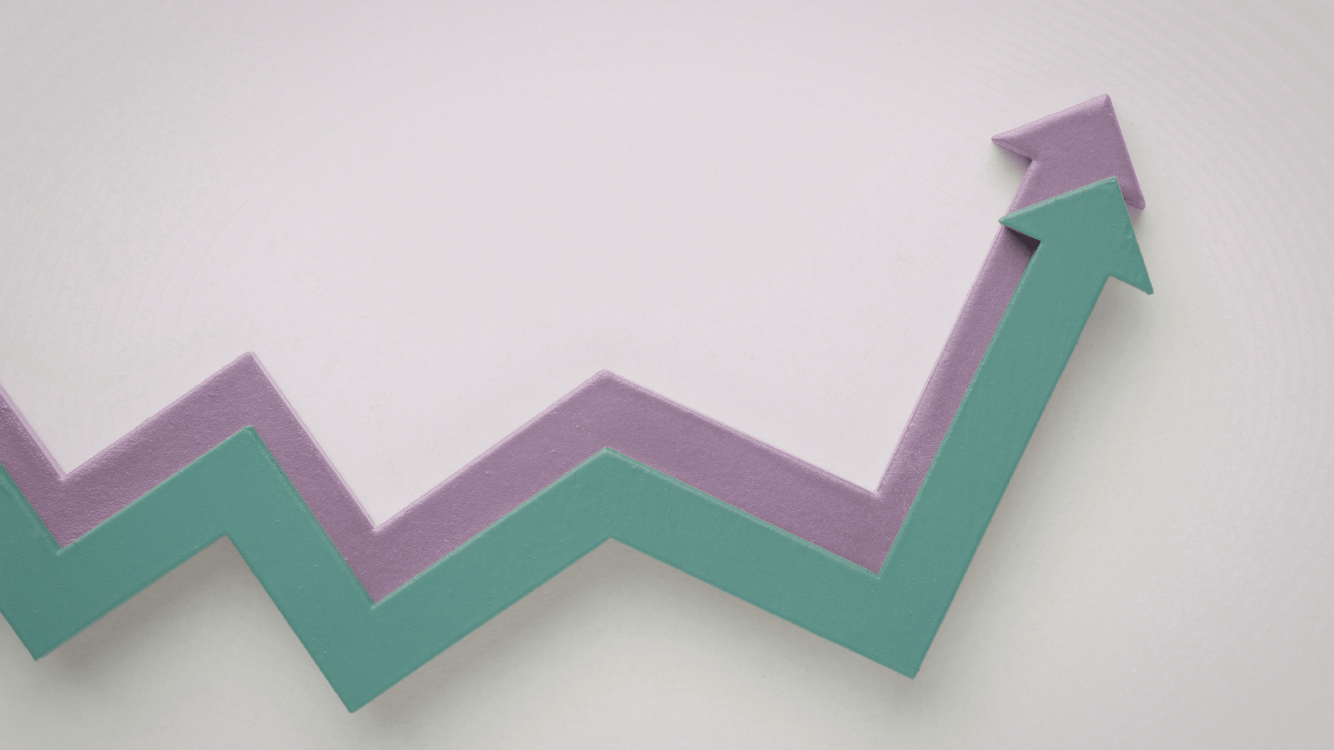 Two upward-trending arrow shapes in teal and lavender against a light background, representing growth and positive outcomes Trauma Therapist Institute