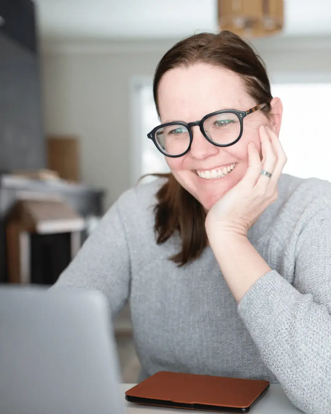 Student smiling at her desk while attending an online Complex PTSD and EMDR training.