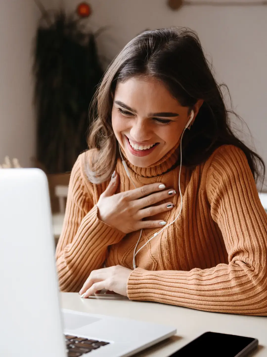Clinician attending a virtual EMDR Mastermind session, smiling while listening with earbuds.